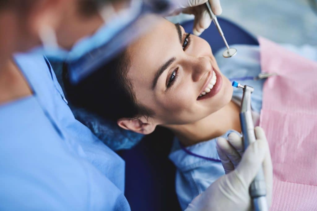 woman in dental chair getting teeth cleaned